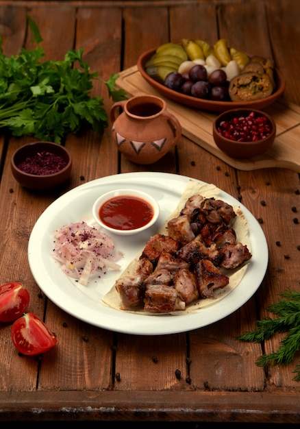 Grilled meat pieces with side onion and ketchup