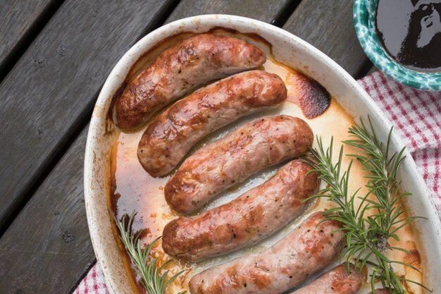 Grilled meat sausages and sauce on table 