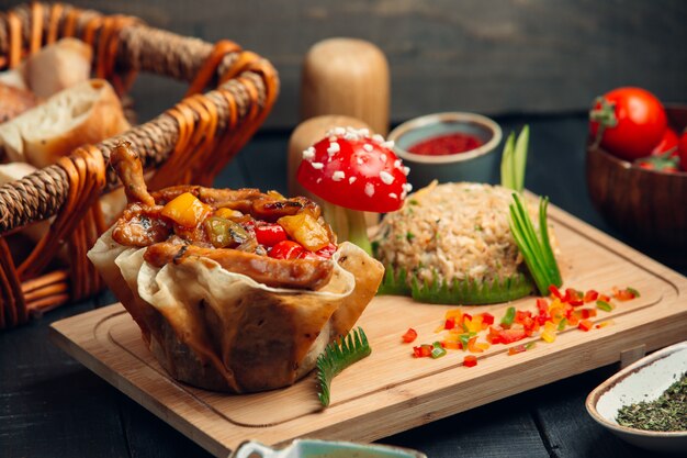 Grilled meat and vegetables inside lavash canape with rice garnish.