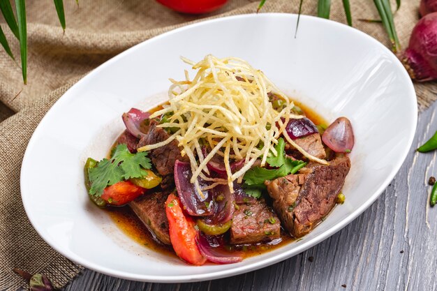 Grilled meat with onion bell pepper tomato parsley side view