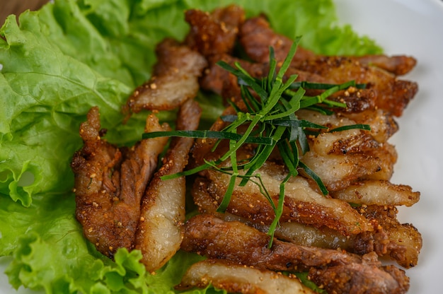 Free photo grilled pork neck on a white plate on a wooden table