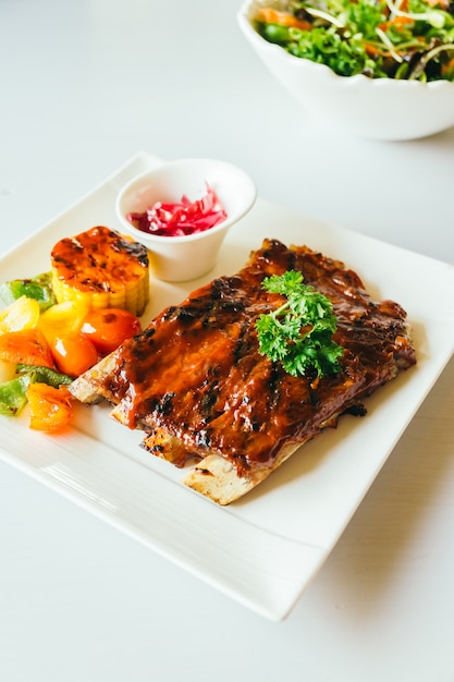 Free photo grilled pork ribs with bbq sauce