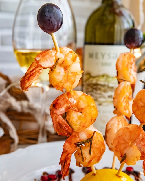 Free photo grilled prawns on wooden stick side view