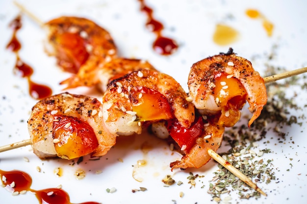 Free photo grilled prawns on wooden sticks with bell pepper rosemary basil side view