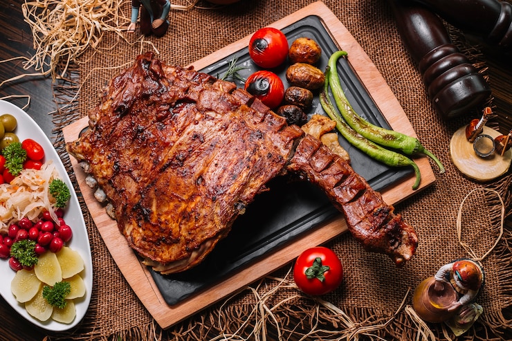 Free Photo grilled ribs on the wooden board tomato pepper potato top view