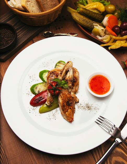 Grilled, roasted chicken steaks and vegetables in white plate with sauce 