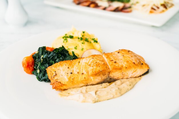 Стейк из филе лосося на гриле с овощами и соусом