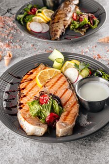 Стейк из лосося на гриле с белым соусом и салатом