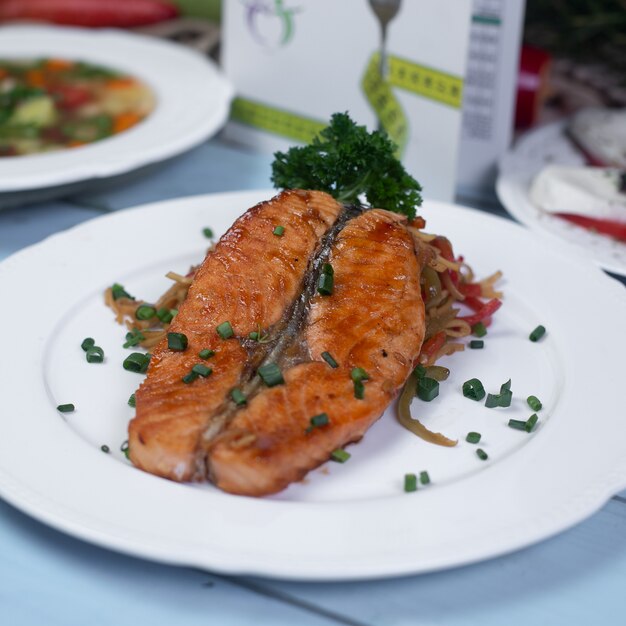 Grilled salmon with herbs and spices in white plate