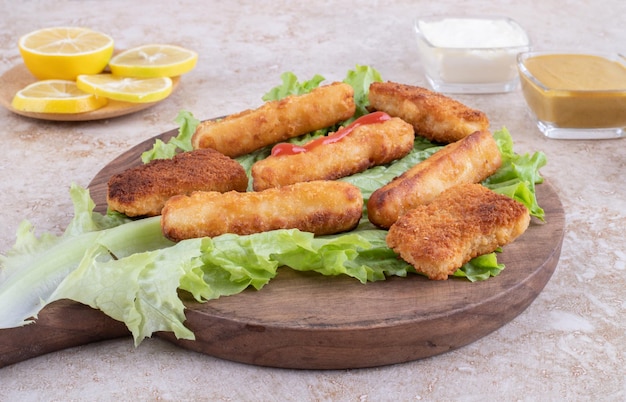 Salsiccia alla griglia e bocconcini di pollo su foglia di lattuga con salse al curry.