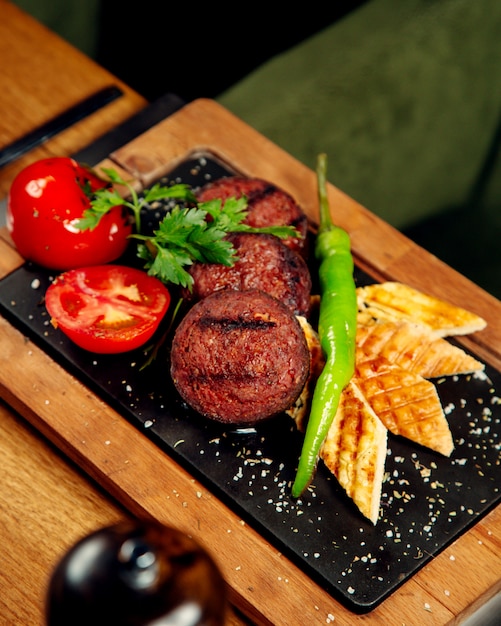 Foto gratuita kebab di salsiccia alla griglia con pane grigliato di pomodoro e pepe