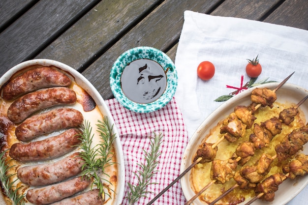 Grilled sausages and shish kebabs on table