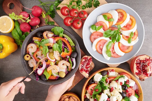 Grilled shrimps and fresh vegetable salad. Healthy food. Flat lay. Italian caprese Salad with tomatoes, basil, mozzarella, Italian traditional caprese salad ingredients. Mediterranean, Greek salad.