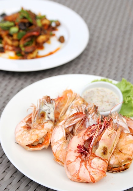 grilled shrimps with seafood sauce on white plate