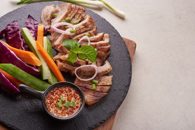Grilled steak with mixed vegetables and spices. Home made tasty food. stone surface. Pork steak with salad. Grilled pork is one of the most popular thai dishes. Grilled pork with spicy dip.