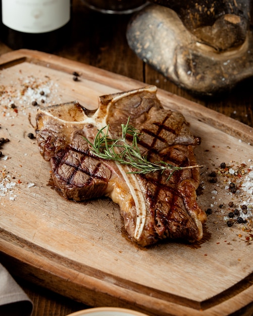Grilled t-bone stake garnished with herbs and salt