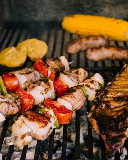 Grilled vegetables and sausages on hot grill charcoal