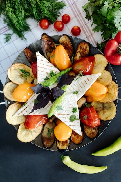 Grilled vegetables served with lavash and greens