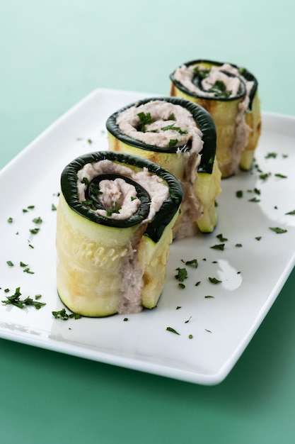 Free photo grilled zucchini rolls stuffed with cream cheese and tuna