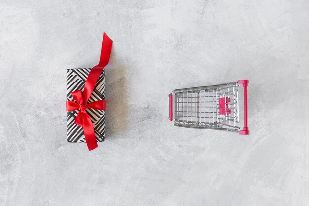 Grocery cart with gift box on table 