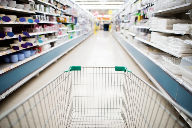 Grocery shopping cart in supermarket aisle 