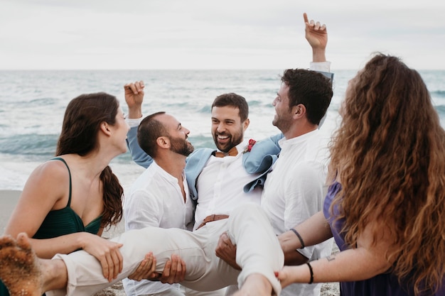 Groom being held by his guests