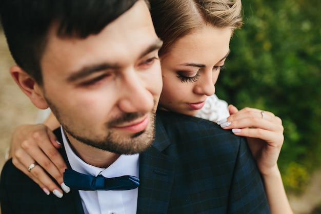 Groom and bride embracing softly