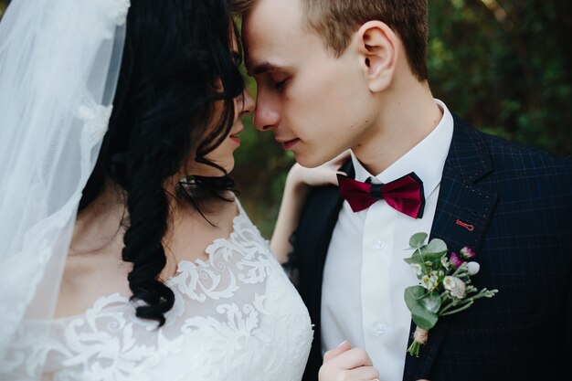 Жених и невеста обнимают трогательные носы