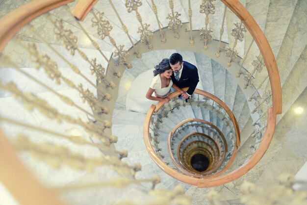 Groom and bride on a spiral staircase