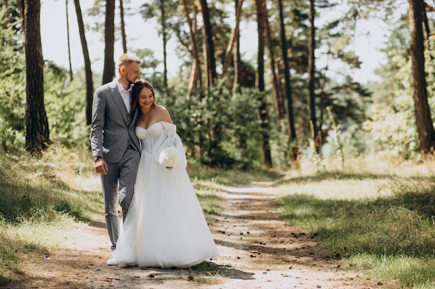 Groom and bride on their wedding day in forest