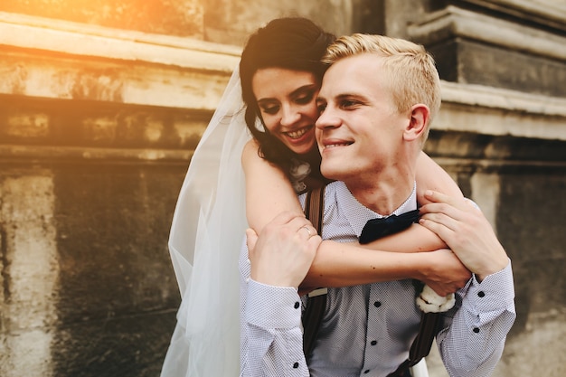 Lo sposo porta la sposa sulla schiena, all'aperto