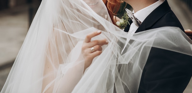 Free photo groom carries charming bride on his arms