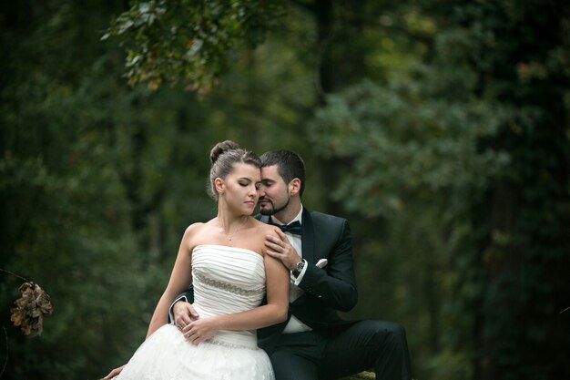 Groom embracing from behind his wife