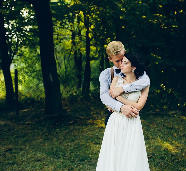 Groom embracing his wife from behind