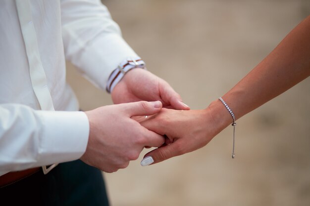 Groom holds bride's hand tender