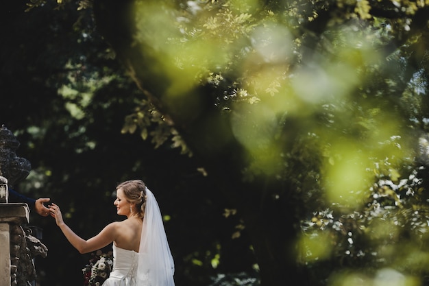 The groom holds hands his bride