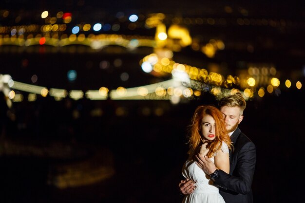 Groom hugging his girlfriend from behind