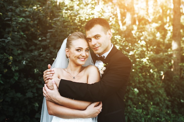 Groom hugging his girlfriend from behind