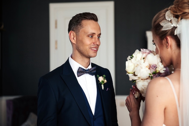 Free photo groom is looking at his beautiful bride