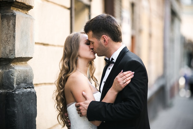 Жених целует красивую невесту на улице