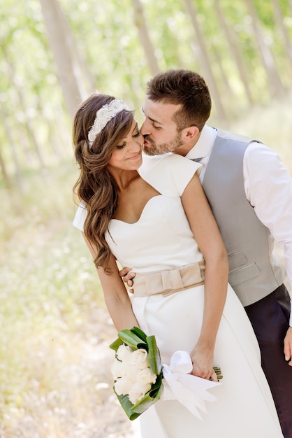 Foto gratuita sposo baciare la sua bella sposa