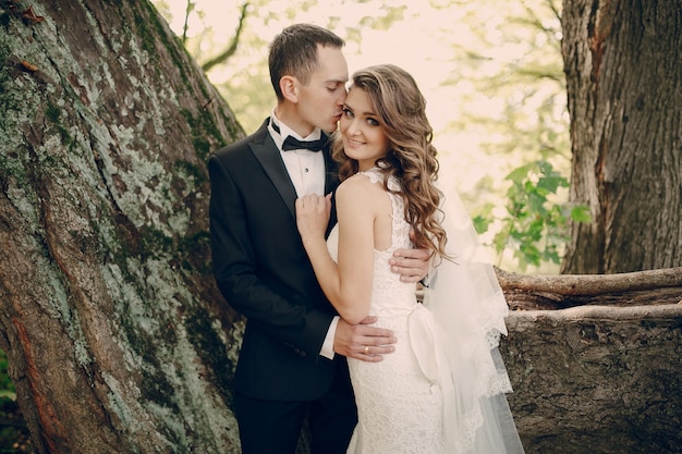 Free photo groom kissing his wife's cheek outdoors