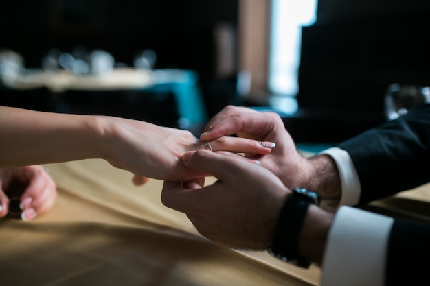 Groom placing the ring on the bride's finger