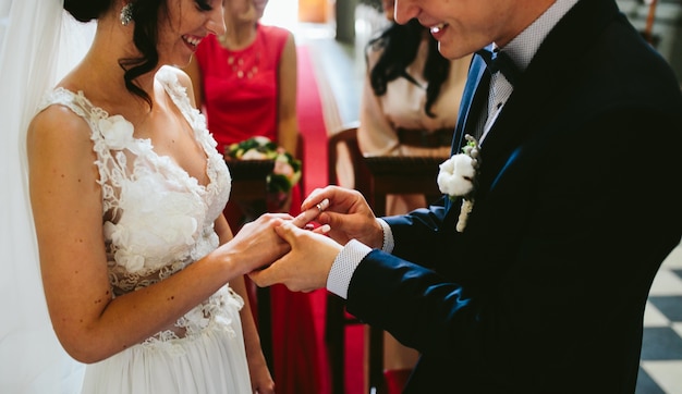 Жених положить кольцо на палец невесты
