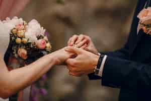 Foto gratuita groom mettendo anello al dito della sposa
