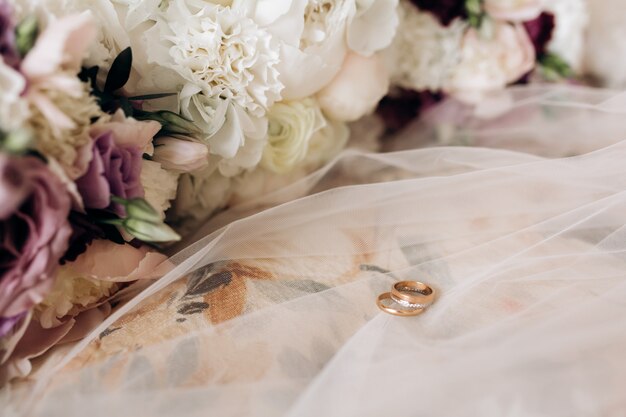 Groom's and bride's weddings rings are on the bridal veil