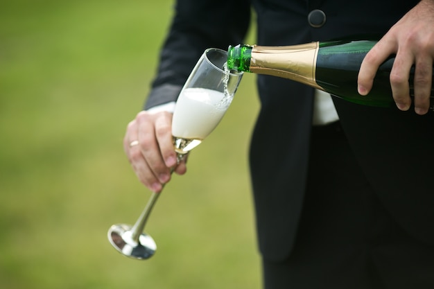 Free photo groom serving a glass of champagne