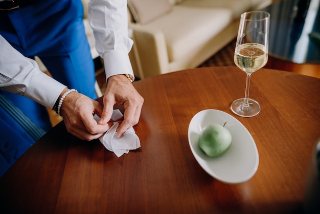 Free photo groom takes a napkin from a wooden table