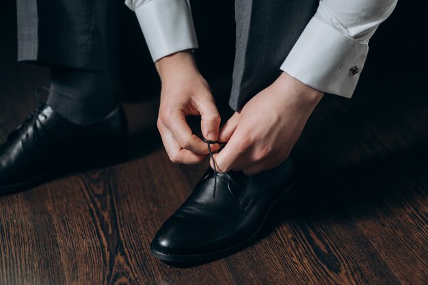 Groom ties laces on his shoes