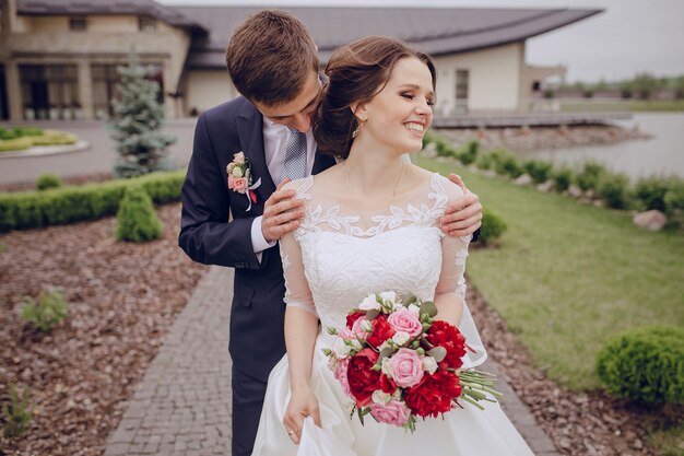 Groom touching the shoulders of his smiling wife